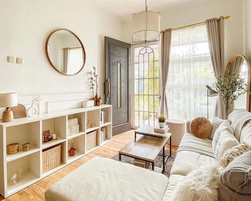 ruang tamu dengan cermin bulat dan rak